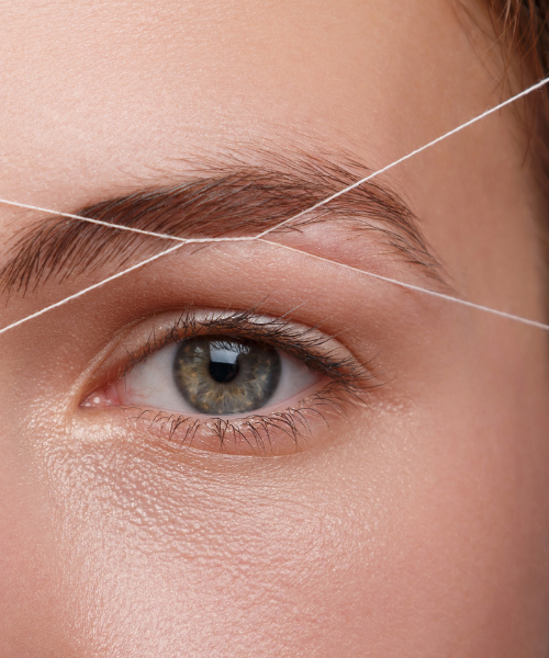 Close-up of an eye during eyebrow threading beauty treatment