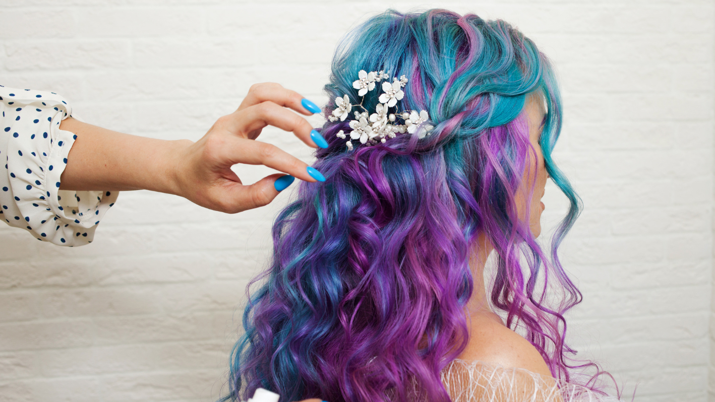 Vibrant blue and purple hair with white flower accessory being adjusted