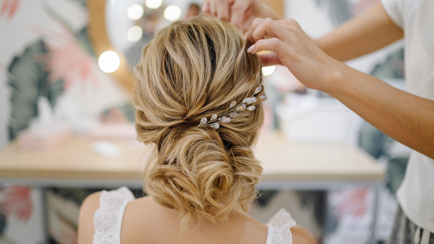 Elegant bridal updo with pearl hair accessory being styled