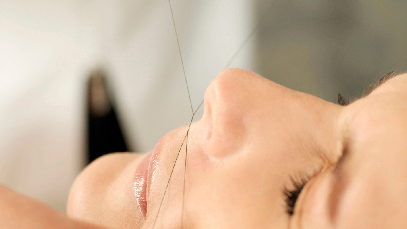 Close-up of face receiving facial threading hair removal treatment